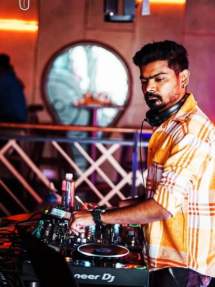 Back at the console, focused on the mix. The warm lighting and unique decor of this venue create a cool, relaxed atmosphere.