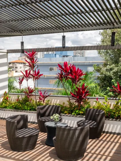 We love designing spaces that play with light. This terrace seating area is shaded by a metal slatted roof that creates an ever-changing pattern of light and shadow throughout the day, providing just the right amount of shade without obscuring the sky.