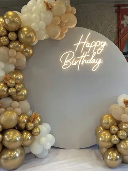 A stunning first impression with this elegant white and gold balloon arch. This classic and sophisticated setup is perfect for milestone birthdays, anniversaries, or any chic celebration, creating a beautiful photo backdrop.