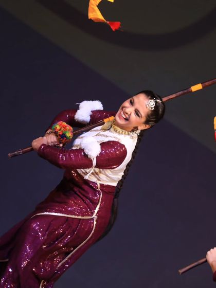 A dynamic action shot of a Bhangra dancer skillfully handling her prop. The energy and movement in this photo perfectly capture the lively spirit of Punjabi folk dance.
