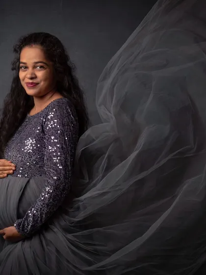 Capturing the magic of motherhood with a dramatic, flowing gown against a classic dark backdrop. This is one of my favorite ways to create timeless maternity art that feels both powerful and elegant.