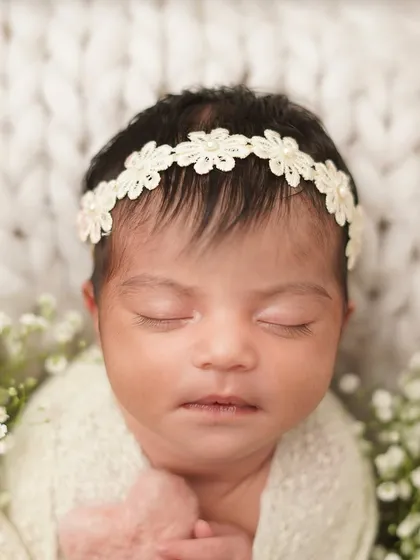 A close-up on the newborn's face, framed by delicate baby's breath. These detail shots are perfect for remembering their tiny, perfect features.