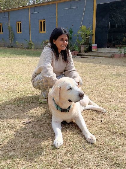 A calm moment with a senior Labrador. Older dogs require a special kind of patience and understanding. Here, Asha sits with this gentle soul, offering quiet companionship that respects its age and pace.
