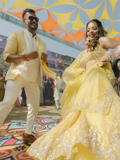 A happy couple making their entry at a daytime Mehendi function. We choreograph for all events.