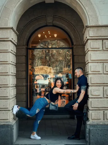 A fun, playful pose in an archway. This photo shows the couple's quirky and fun-loving personalities during their city shoot.