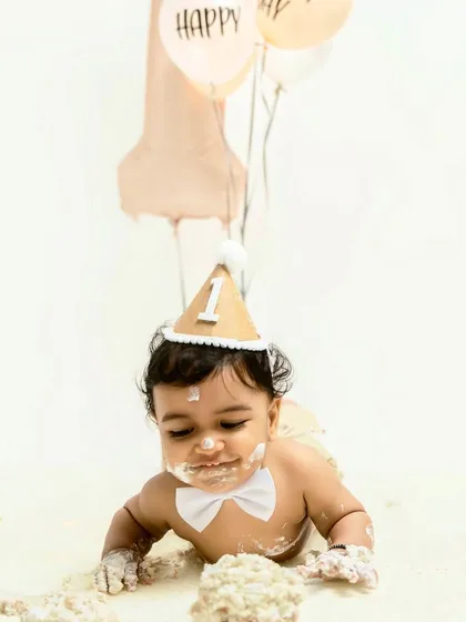 Fully embracing the mess. This little one is crawling through the cake and frosting, a perfect shot that captures the hilarious and adorable chaos of a cake smash session.