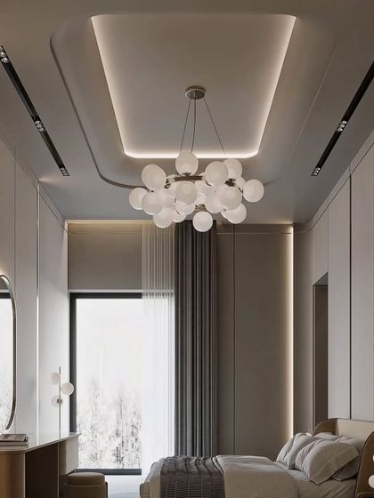 A beautiful bedroom with a modern globular chandelier and integrated wardrobe. The neutral color palette creates a calm and soothing atmosphere.