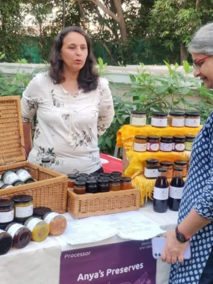 A vendor at her stall, which is filled with a wide variety of homemade preserves, jams, and sauces.