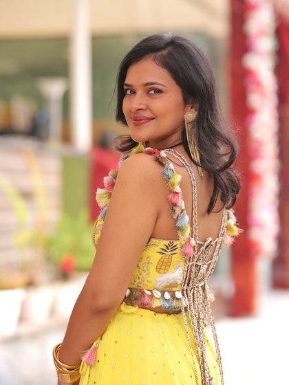 A playful and chic Haldi outfit for the sister of the groom. This customized Payal Singhal ensemble features fun animal motifs and colorful tassels, perfect for a daytime celebration.