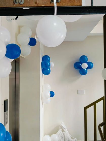 Simple blue and white balloon clusters used to decorate a hallway and staircase for an event.