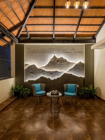 A balcony with a view of the mountains. This space features a stunning backlit mural of a mountain range, creating a dramatic and artistic backdrop for the cozy seating area.