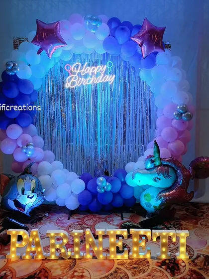A fun Tom and Jerry themed birthday party with a unicorn twist. This decoration features a circular balloon arch, a shimmering backdrop, character balloons, and a custom neon sign.