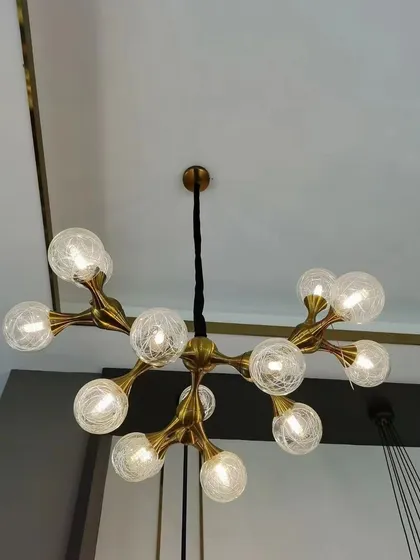 This modern chandelier features a branching structure with textured glass globes. The artistic design is both beautiful and functional, providing ample light while serving as a sculptural focal point.