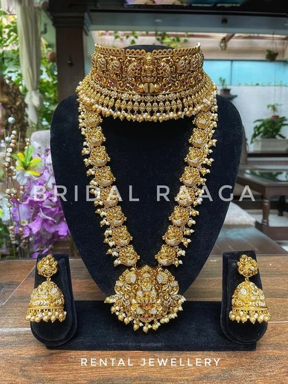 An elegant temple jewellery set featuring a Lakshmi choker and a long haram, both finished with delicate pearls. This set is available for rent.