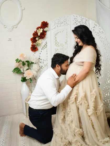 A classic pose of love and anticipation, with the father-to-be kneeling to kiss the baby bump. This shot is a testament to the beautiful journey of pregnancy.