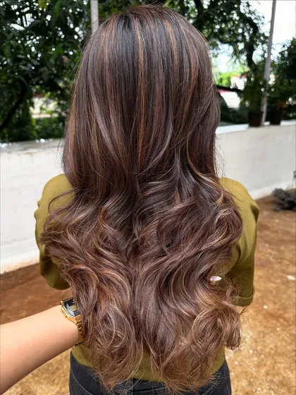 Getting her 'Vacay Hair' on with these beautiful ribbon highlights. This technique creates a gorgeous, flowing look that’s perfect for showing off on your next trip.