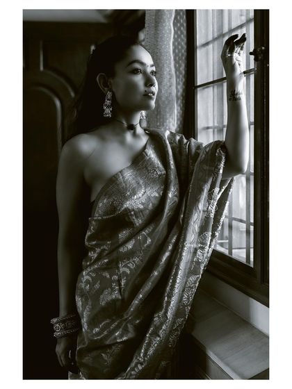 A black and white shot of the woman looking out a window, creating a sense of longing and quiet beauty. This is an example of my narrative portrait style.