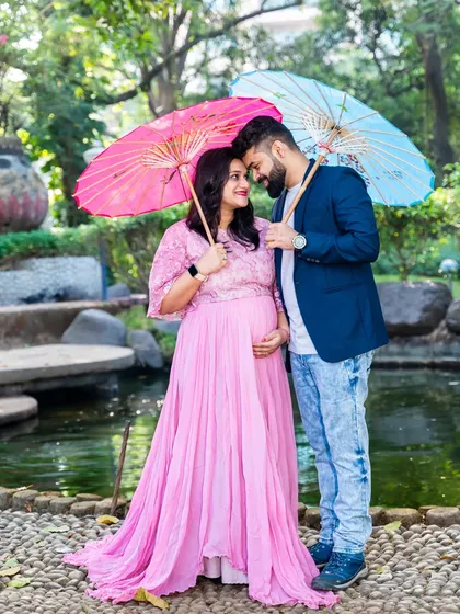 A playful and colorful shot using pink and blue umbrellas as props, hinting at the "boy or girl" question in a creative way.