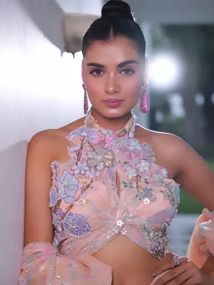 A close-up of the pastel peach fusion gown. The styling highlights the intricate 3D floral embroidery on the halter-neck blouse.
