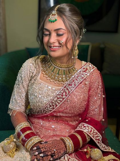 The bride's serene expression is enhanced by her soft, romantic hairstyle. The bun is adorned with flowers to add a touch of freshness.