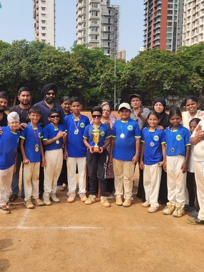 A diverse team of young champions and their families celebrating a tournament win. We are proud to bring together children from all backgrounds through sports.
