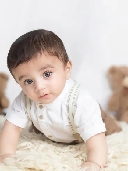 A crawling pose with his two teddy bear friends in the background. The soft fur rug is perfect for babies to lie and sit on.