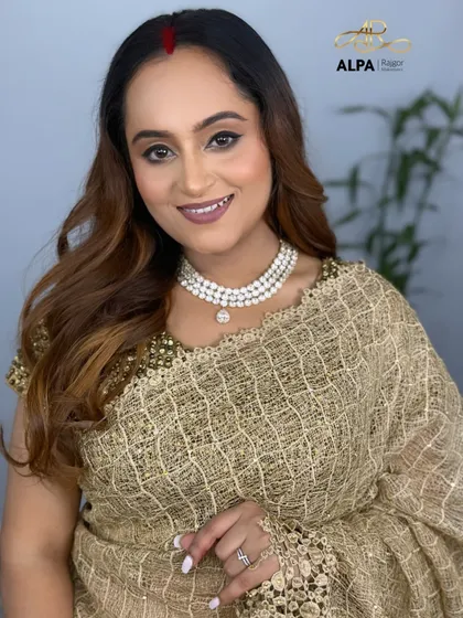 An elegant look for a party or wedding function. The makeup features soft, shimmery eyes and a flawless base that doesn't settle into fine lines.
