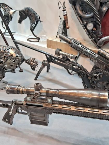 Detailed metal sculptures of sniper rifles, showcasing incredible craftsmanship and attention to detail in a surprising and thought provoking medium.