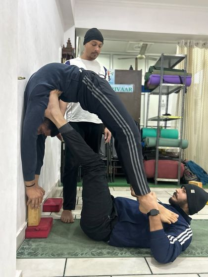 This is an advanced partner stretch using the wall, a technique I learned during my training. It shows the level of trust and physical openness that can be achieved through dedicated practice under the right guidance.