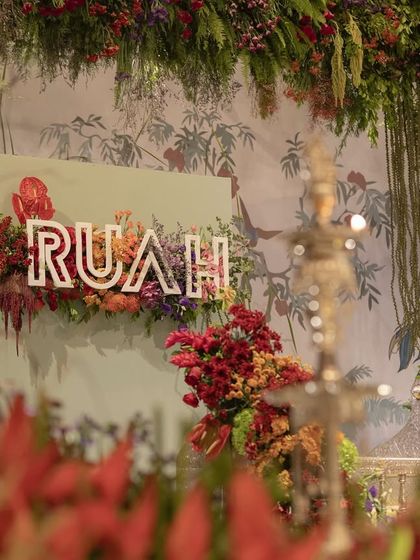 The baby's name, 'Ruah', displayed on a sign amidst the lush decor of the naming ceremony.