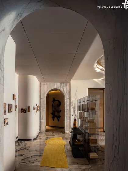 This sculpted curve in the Palais Royale apartment guides movement with intention, softening the geometry of the home’s asymmetric layout. Subtle brass accents, exquisite marble, and fluted detailing elevate this in-between space into a spatial highlight.