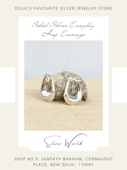 A product shot of our solid silver everyday U-shaped hoop earrings, displayed on a natural jute background to emphasize their simple, clean design.