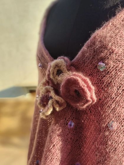 A close-up of the hand-knitted flower brooch and delicate sequin details on my purple shrug. It's these little touches that make a handmade item so special.