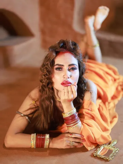 A direct and engaging portrait from our 'Hai Rama' series. The model's expression, combined with the traditional bangles and mirror prop, tells a compelling story.