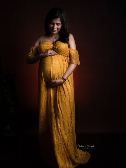 A quiet, contemplative pose in a yellow lace gown against a dark, moody background. The lighting creates a beautiful, intimate feel.