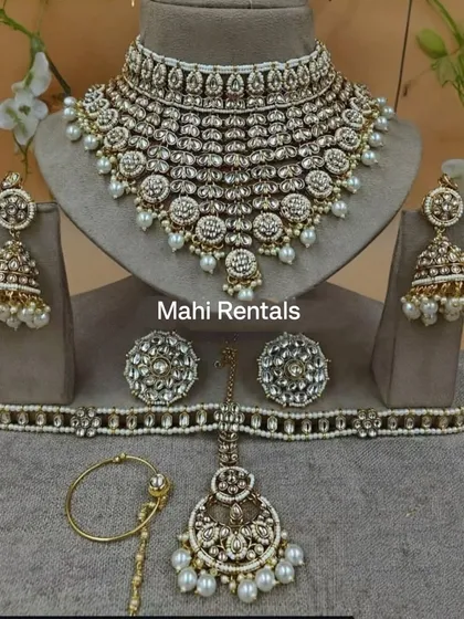 A complete white Kundan bridal set including a heavy choker, jhumkas, hathphool, nath, and maang tikka.