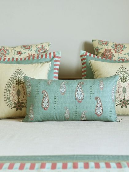 A closer view of the cushion arrangement, highlighting the intricate paisley and floral block prints. The striped borders add a classic touch, tying the whole collection together beautifully.