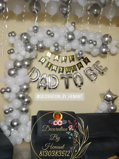 Another angle of the "Dad To Be" birthday setup. The L-shaped balloon garland is made of white and chrome silver balloons, creating a stylish and celebratory corner in the home.