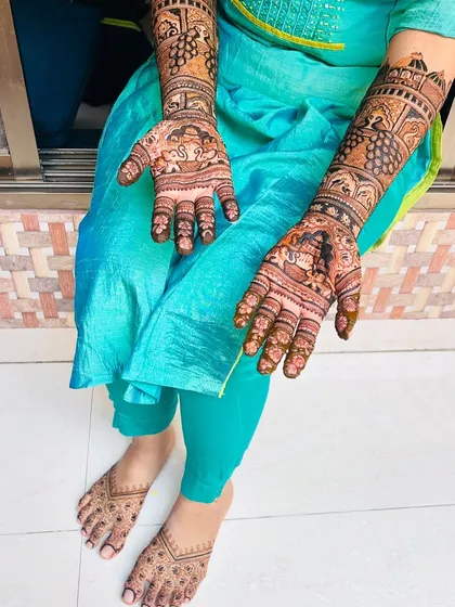 The full view of an engagement mehendi set, with detailed work on both hands and simpler, elegant patterns on the feet.