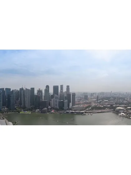A wide panoramic shot of the Singapore skyline and Marina Bay, taken from a high vantage point during the day.
