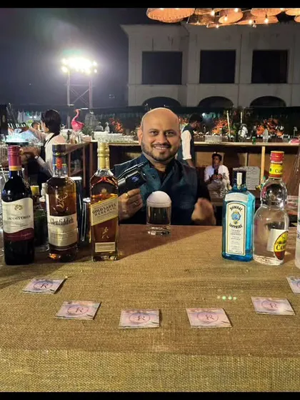 A simple yet effective bar setup for an outdoor event. The burlap-covered table and display of premium spirits like Johnnie Walker and Grey Goose show that we can create a great bar experience in any setting.