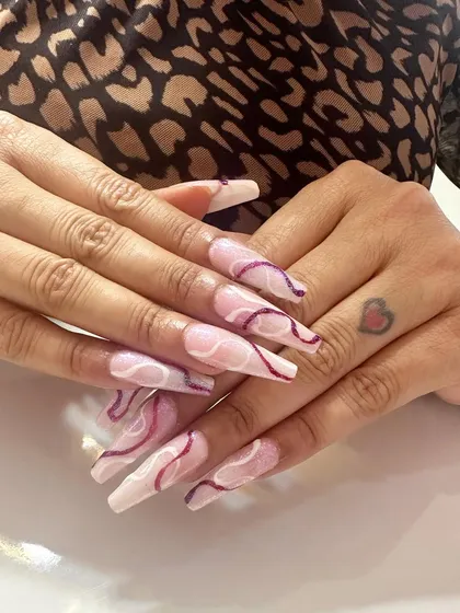 This design shows my skill with fine line work. On a neutral, milky base, I hand-painted delicate swirls in white and deep purple, creating an abstract and artistic look on long, squared nail extensions.