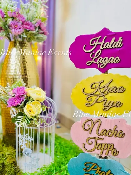 A close-up of the fun and quirky props I provide for Haldi ceremonies. Signs like 'Haldi Lagao', 'Khao Piyo', and 'Nacho Tappo' add a playful element for guests' photos.