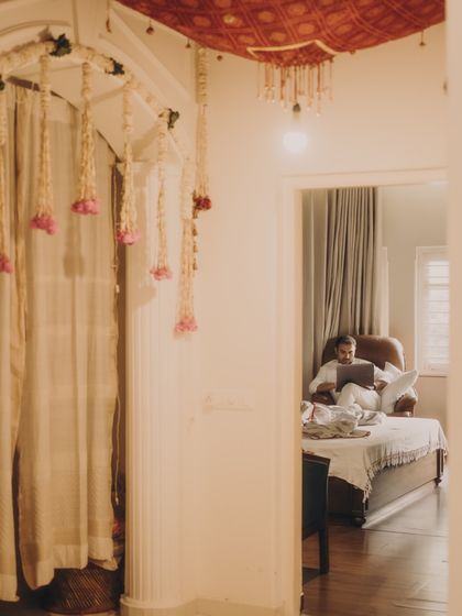 A quiet moment captured during the home festivities. This image shows the groom relaxing amidst the wedding decor, part of the 'Dal Makhani Aesthetic' that celebrates the calm, intimate moments.