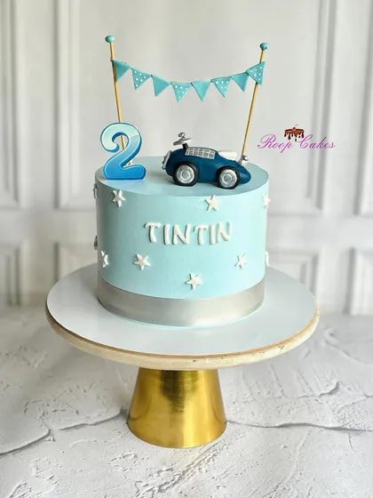 Vrooming into two. A cute little cake for a cute little boy, this design features a vintage car topper and a sweet blue bunting.