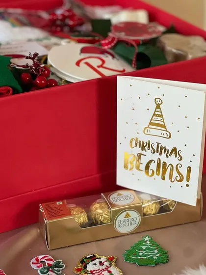 Christmas begins with a box of joy! This Secret Santa hamper for kids is filled with Ferrero Rocher, a personalized ornament, and other festive goodies.