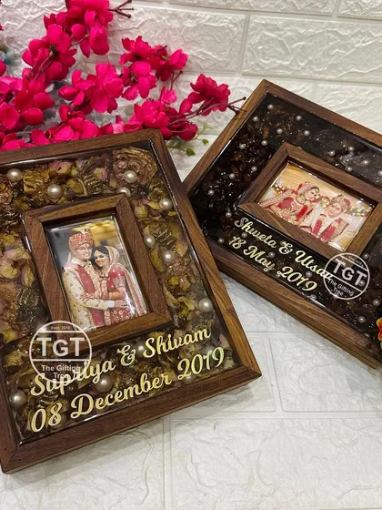 This image shows two different teakwood frames side-by-side, demonstrating the range of customization with different flowers and resin colors.