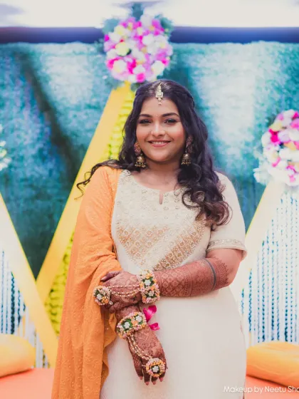 A golden glow for the bride-to-be. This portrait captures the serene and happy moments before the Haldi rituals begin.