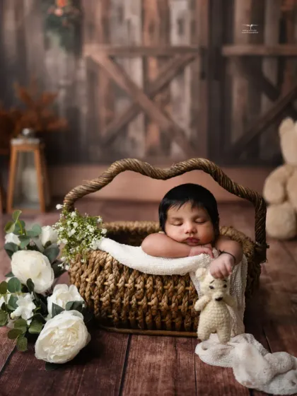 Nestled in a woven basket with white flowers, this newborn is the picture of serenity. My studio is full of beautiful props to create these artistic newborn compositions.