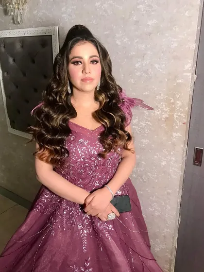 Another angle of Anisha's engagement look. The high ponytail and soft waves perfectly complement the glamorous makeup, creating a chic and modern party look.